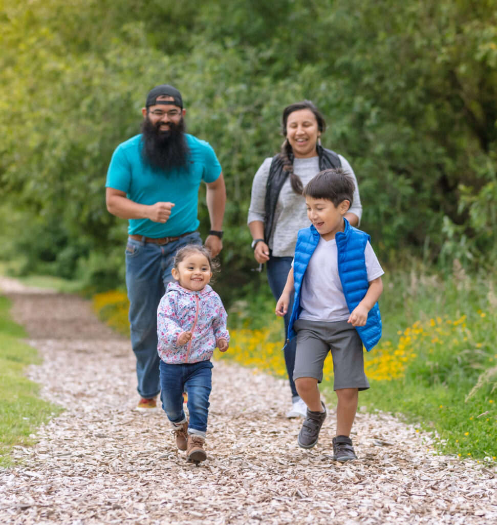 Two young kids and their parents walking out in nature